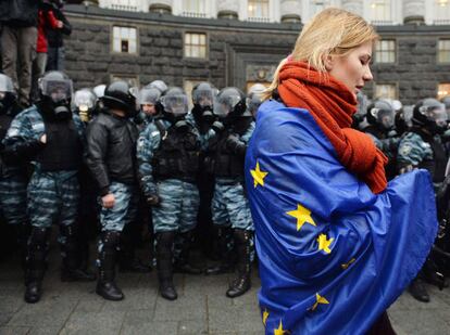 Una mujer se pasea con la bandera de la Unión Europea en el exterior de la sede del Gobierno ucraniano en Kiev, 25 de junio de 2013.