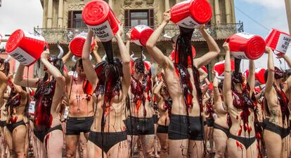 Frente al Ayuntamiento de la capital navarra, los participantes en la protesta contra los Sanfermines se han quedado en ropa interior y se han lanzado por encima baldes de sangre falsa.