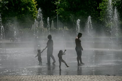 Dos niños juegan en las fuentes de Madrid Río.