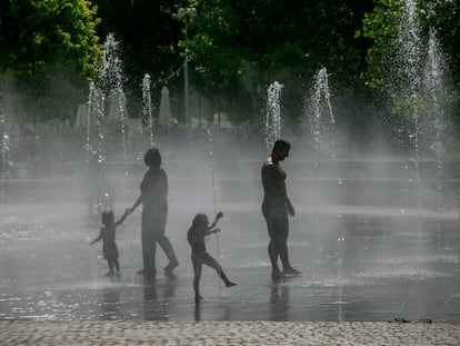 Dos niños juegan en las fuentes de Madrid Río.