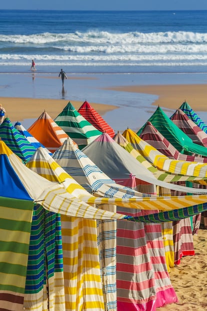 De 1,5 kilómetros de largo y con 140 casetas, una de las características más vistosas de la playa de San Lorenzo. Otro dato para tener en cuenta: con pleamar, este arenal en forma de concha desaparece en un 80%. Es una de las playas más conocidas de Asturias, de arena fina y dorada, y perfecta para iniciarse en el surf. Delimitada al oeste por el Cerro de San Catalina y, al este, por la desembocadura del río Piles, la bordea un paseo marítimo apodado El Muro, de casi tres kilómetros de recorrido. Más información: <a href="https://www.turismoasturias.es/descubre/costa/playas/playa-de-san-lorenzo" target="_blank">turismoasturias.es</a>