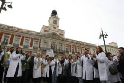 Más de un centenar de médicos residentes se concentraron ayer en la Puerta del Sol para protestar contra la privatización de la gestión de seis hospitales y 27 centros de salud.