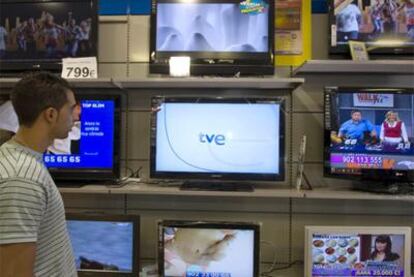 Un hombre observa televisores en un comercio