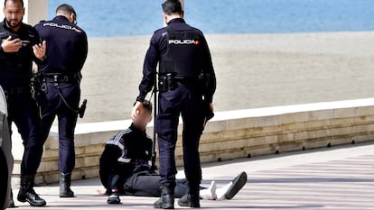 Miembros del Cuerpo Nacional de la Policía detienen a un ciclista en el paseo marítimo de Almería los primeros días tras la declaración del estado de alarma, en marzo de 2020.
