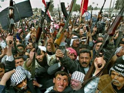 Decenas de hombres  armados protestan por las calles de la ciudad iraquí de Babilonia contra EE UU.