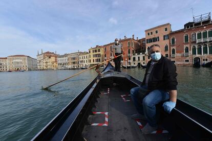 Un gondolero traslada a su primer cliente tras reanudarse el servicio en la ciudad de Venecia (Italia). Las góndolas ofrecen sus servicios a los habitantes de la ciudad ante la ausencia de turistas.