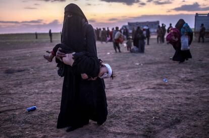 Una mujer evacuada de Baghuz lleva en brazos a su hijo herido mientras se dirige hacia el puesto de las milicias kurdas, el 4 de marzo.