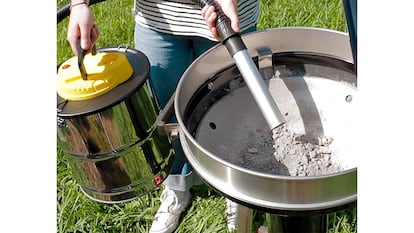 Aspirador ceniza usado por una persona en una barbacoa