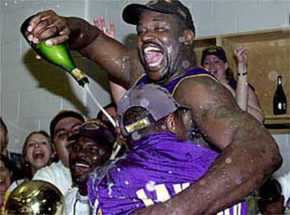 Shaquille O'Neal derrama una botella de champaña sobre uno de los ayudantes tras el triunfo.