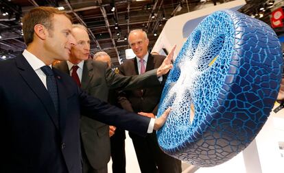 El consejero delegado de Michelin, Jean Dominique Senard (centro) muestra un prototipo de neumático al presidente francés, Emmanuel Macron (izquierda) en el salón del automóvil de París. 