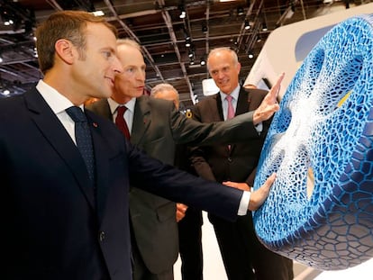 El consejero delegado de Michelin, Jean Dominique Senard (centro) muestra un prototipo de neumático al presidente francés, Emmanuel Macron (izquierda) en el salón del automóvil de París. 