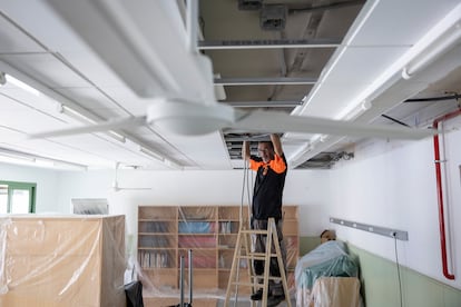 Operarios instalando aire acondicionado en una escuela de Barcelona.