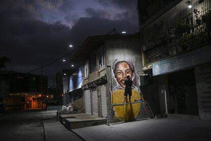 El artista callejero Wolfgang Salazar trabaja en su mural sobre la atleta venezolana Yulimar Rojas, en el barrio Boleita de Caracas (Venezuela).