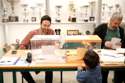 Un niño juega con una urna electoral en el colegio de Nuestra Señora del Buen Consejo, en Madrid.