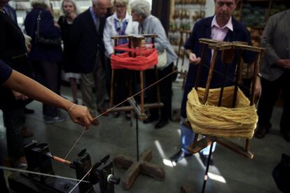 El gobierno regional de Sajonia (Alemania) ha encargado 32 tapices por valor de 1,2 millones de euros. En la imagen, visitantes observan como los artesanos utilizan una rueca para hacer un huso de colores combinados para sus tapices en la Real Fábrica de Tapices en Madrid.