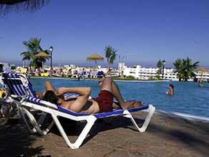 Un hombre descansa junto a la piscina de un hotel de Almería.