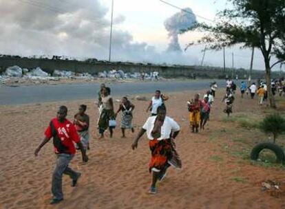 Varias personas escapan del lugar en el que se produjo una explosión, en un polvorín de Maputo, Mozambique.