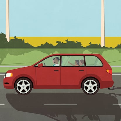 Family in car on vacation pulling camper trailer, driving past wind turbines in idyllic countryside