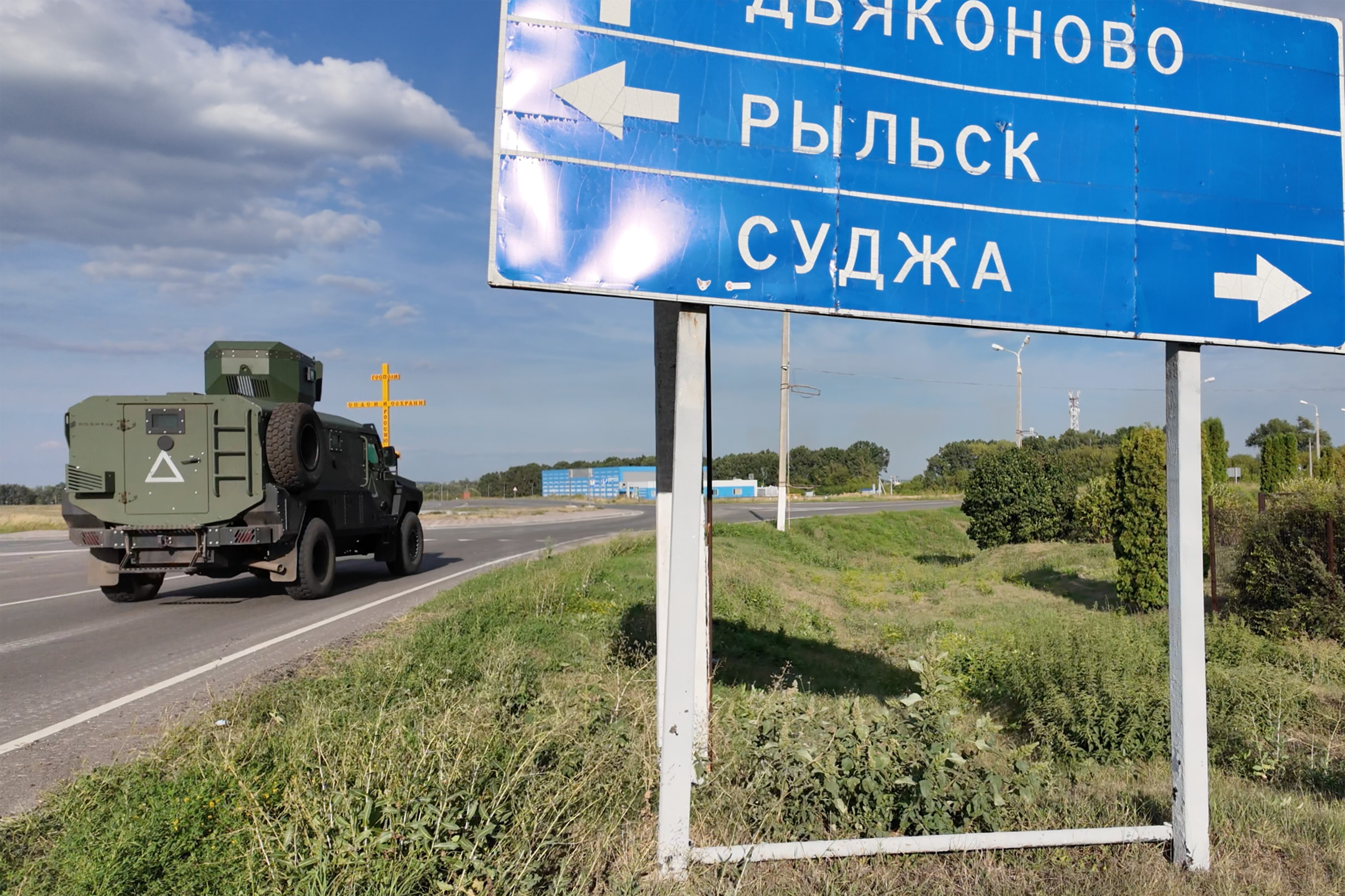 Unidade de assalto ucraniana em Kursk. Um 'stryker' passa por uma placa de trânsito para Sudzha.