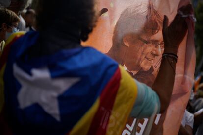 Un hombre sujeta una imagen del expresidente catalán Carles Puigdemont durante una protesta contra su detención frente al consulado italiano en Barcelona, este viernes.