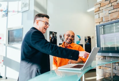 Dos profesionales de marketing, trabajando junto a un ordenador portátil.