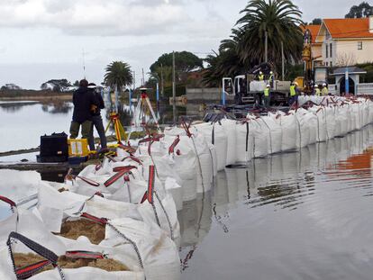 Colocación de sacos de arena para frenar el desbordamiento de la laguna protegida de A Frouxeira