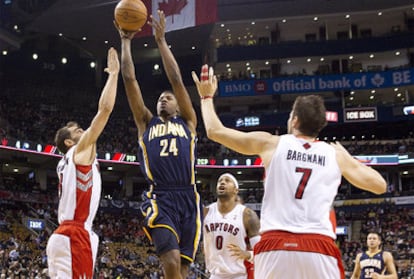 Paul George intenta encestar entre varios jugadores de Toronto