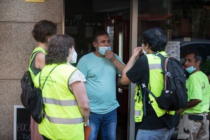 Un equipo de informadores piden a un comerciante que guarde las medidas de seguridad.