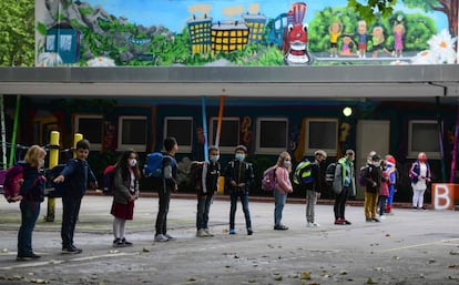 Students line up for the entrance at the schoolyard of the Petri primary school in Dortmund, western Germany, on June 15, 2020 amid the novel coronavirus COVID-19 pandemic. - From June 15, 2020, all children of primary school age in the western federal state of North Rhine-Westphalia will once again be attending regular daily classes until the summer holidays. The distance rules and compulsory mouthguards are no longer applicable. (Photo by Ina FASSBENDER / AFP)