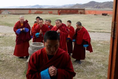 Los monjes budistas entran en ger, una tienda de Mongolia tradicional, para las oraciones de la tarde en el monasterio de Amarbayasgalant en Baruunburen (Mongolia).