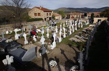 Vecinos de Prádena del Rincón (Madrid) limpian las tumbas de sus familiares.