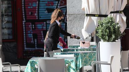 Una joven camarera trabajando en una terraza de la Plaza Mayor (Madrid).