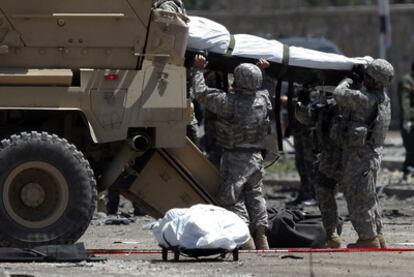 Soldados estadounidenses cargan el cadáver de uno de sus compañeros fallecidos ayer en el centro de Kabul.