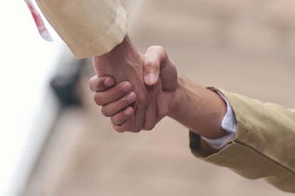 Dos hombres se estrechan las manos a modo de saludo.