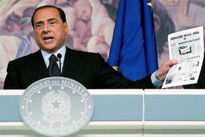 Silvio Berlusconi muestra la copia de un periódico durante su conferencia de prensa ayer en Roma.