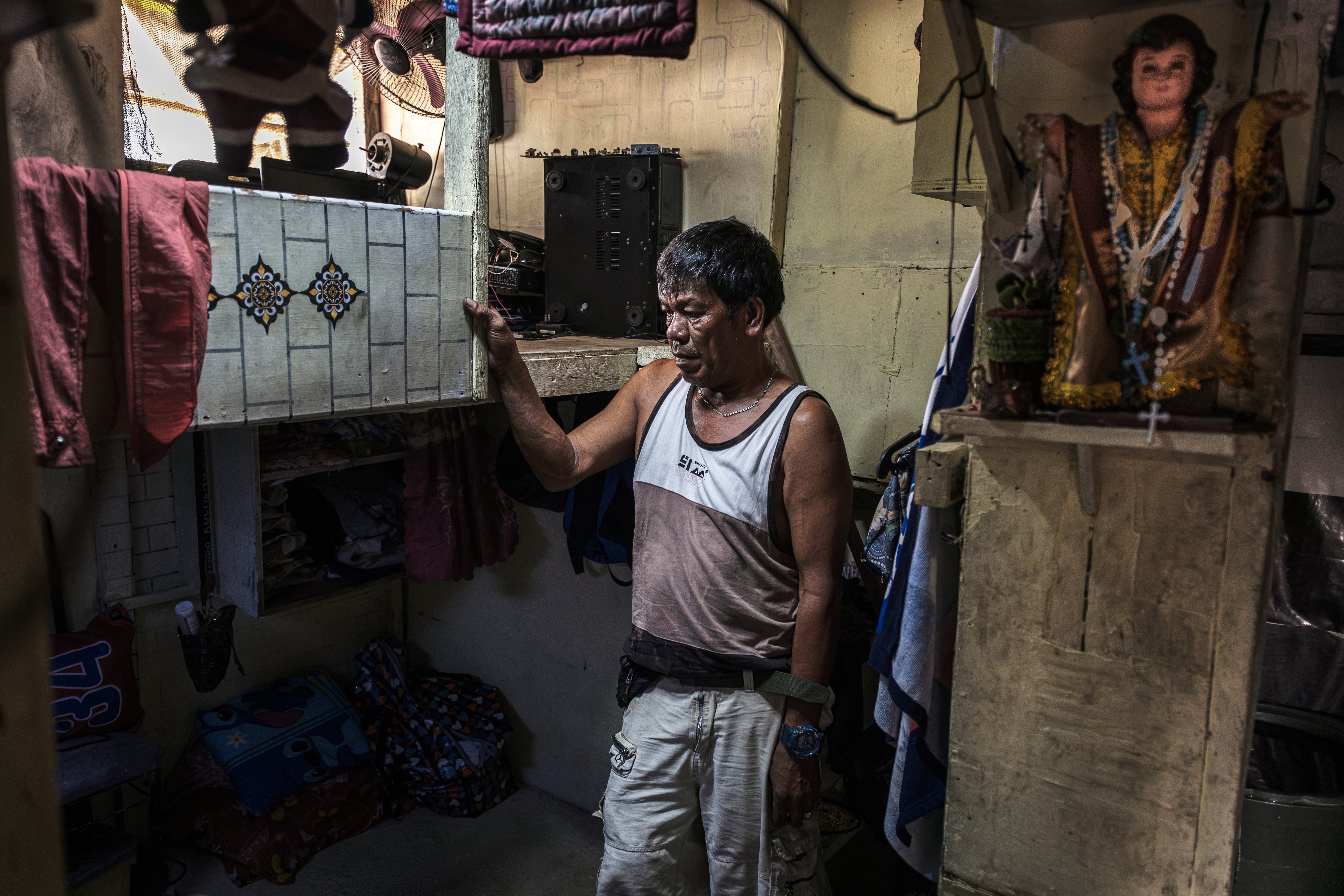 Felipe Parco dentro de la habitación donde vive. Los desmanteladores se encuentran entre las personas más pobres de Filipinas, con ingresos diarios de 