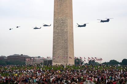 Asistentes al desfile mientras helicópteros de diferentes modelos sobrevuelan Washington.
