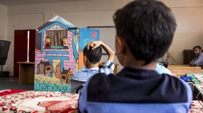 Estudiantes escuchan a dos títeres en el Colegio Túnez en la Franja de Gaza.