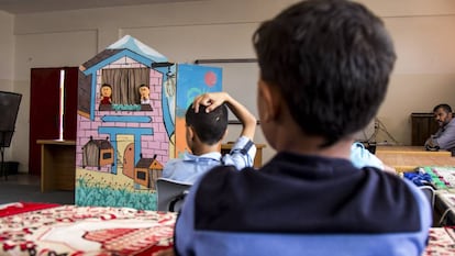 Estudiantes escuchan a dos títeres en el Colegio Túnez en la Franja de Gaza.