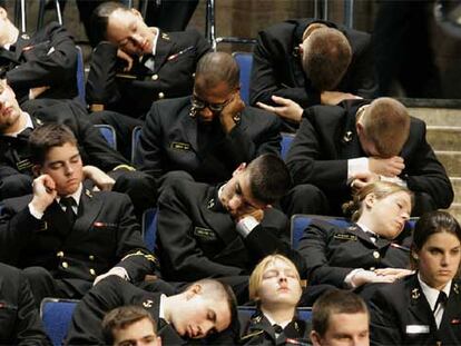 Cadetes de la Academia Naval de Annapolis dormitan mientras esperan la llegada del presidente George W. Bush.