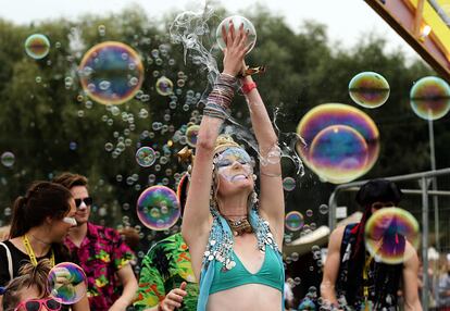 Una asistente rodeada de burbujas de jabón durante el Bestival (Inglaterra).