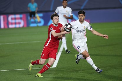 Marco Asensio pelea un balón con el defensa escocés del Liverpool Andrew Robertson.