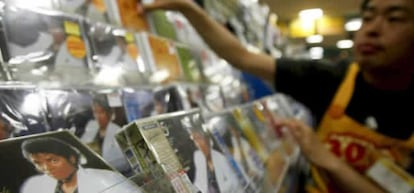 Un empleado de una tienda de música coloca varios CDs de la estrella del pop Michael Jackson, en Tokio