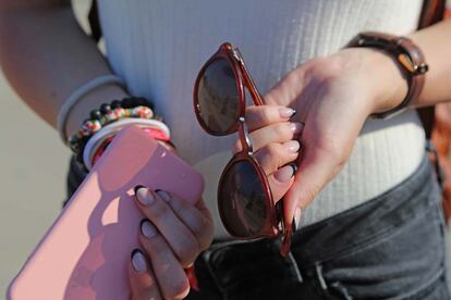 Detalle de su manicura, sus pulseras y sus gafas de sol.