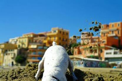 Un perro escarbando en la arena en una playa italiana.