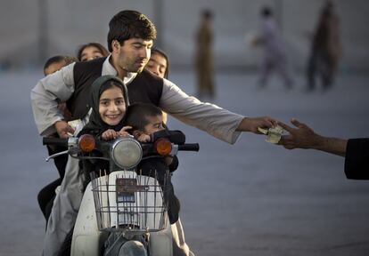 Un hombre lleva a sus cinco hijos en su moto y paga la entrada de un parque en Kandahar, al sur de Afganistán, 1 de noviembre 2013.