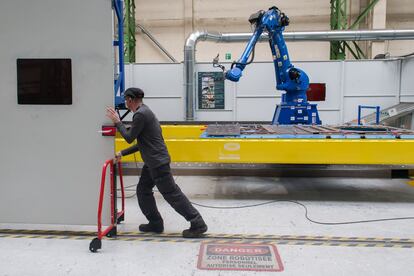 Un empleado prepara un robot en una fábrica del grupo Volvo en Garchizy, Francia.