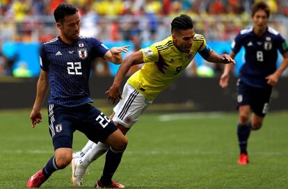 Radamel Falcao cae ante el defensa japonés Maya Yoshida, durante el partido Colombia-Japón