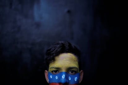 Un manifestante posa, con la cara pintada con la bandera venezolana, durante las protestas.