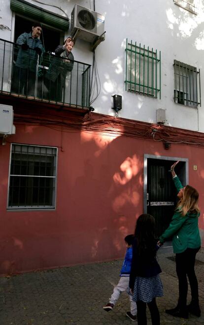 Susana Díaz saluda a unos vecinos del barrio sevillano de Triana durante la jornada electoral.